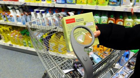 Eine Frau betrachtet in Langenhagen bei Hannover einen Verkaufsartikel durch eine am Einkaufswagen einer Drogeriekette angebrachte Lupe.