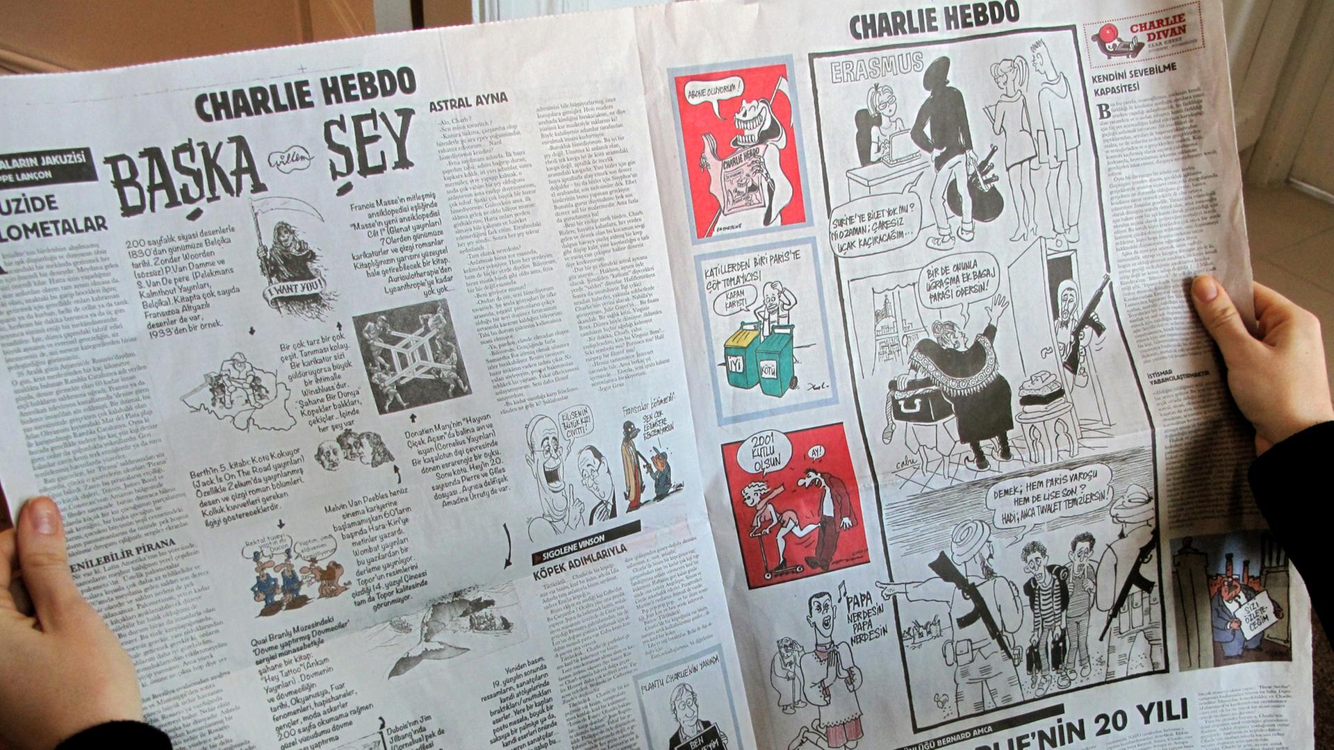 Eine Frau blättert am 14.01.2015 in Istanbul in der Zeitung "Cumhuriyet", die vier Seiten der neuen Ausgabe von "Charlie Hebdo" als Beilage nachdruckte.