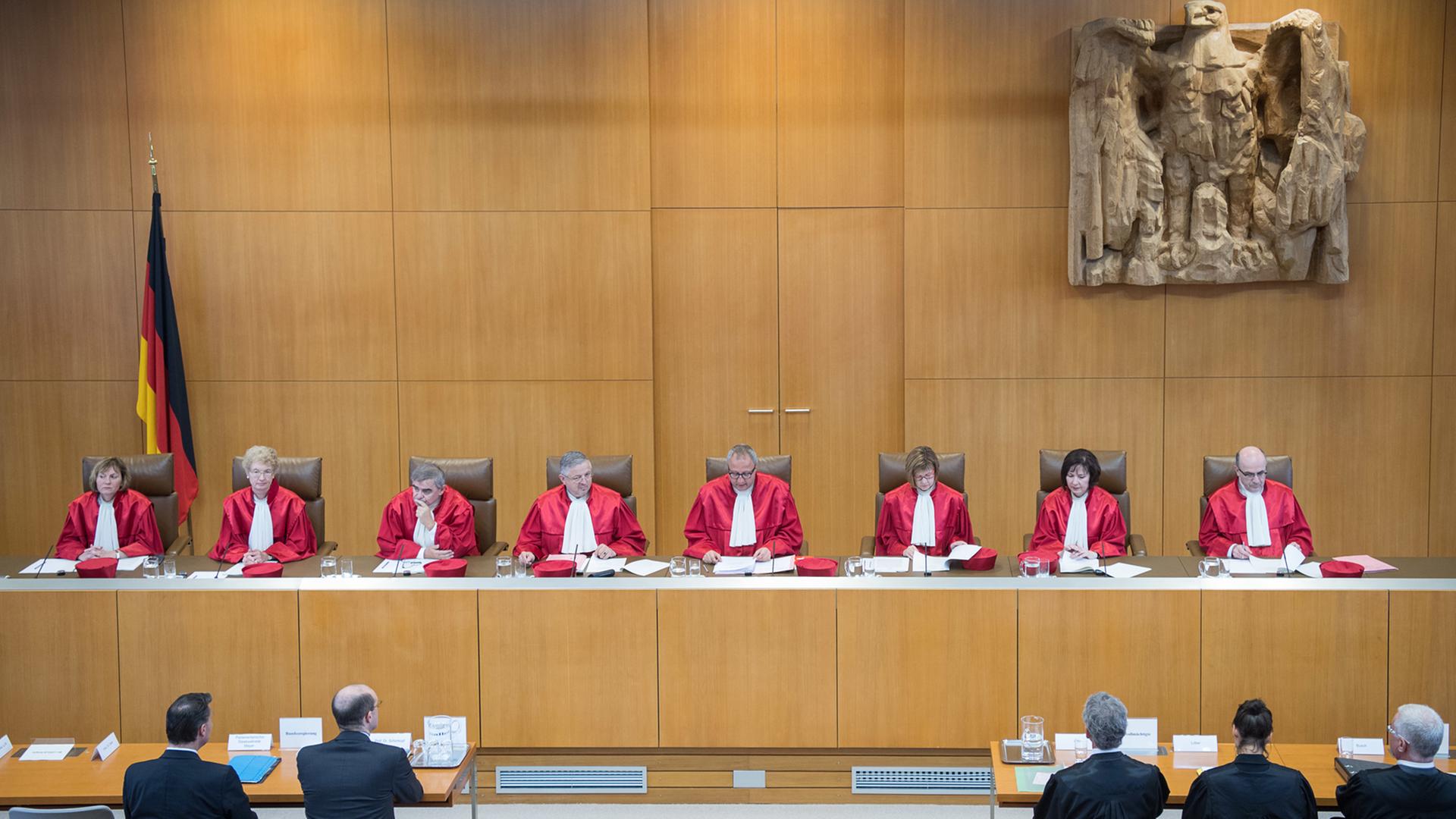12.06.2018, Baden-Württemberg, Karlsruhe: Die Richter des Zweiten Senat des Bundesverfassungsgerichts, Christine Langenfeld (v-l), Doris König, Peter Müller, Peter M. Huber, Andreas Voßkuhle, Vorsitzender des Zweiten Senats und Präsident des Bundesverfassungsgerichts, Monika Hermanns, Sibylle Kessal-Wulf und Ulrich Maidowski, sitzen während der Urteilsverkündung des Zweiten Senats des Bundesverfassungsgerichts zum Streikverbot für Beamte auf der Richterbank.