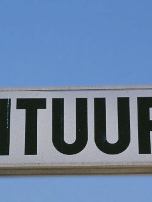 Ein Schild mit der Aufschrift "Frituur" mit einer Möwe drauf.