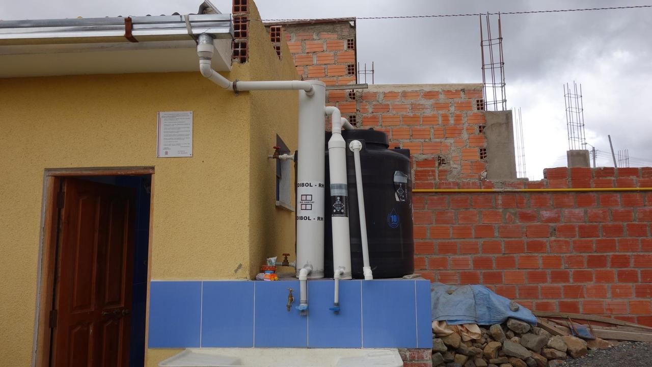 Neben dem Haus von Estefa Ramos steht ihre Regenwasserauffanganlage mit mehreren Hähnen und Kanistern, die das Wasser vom Dach filtern.