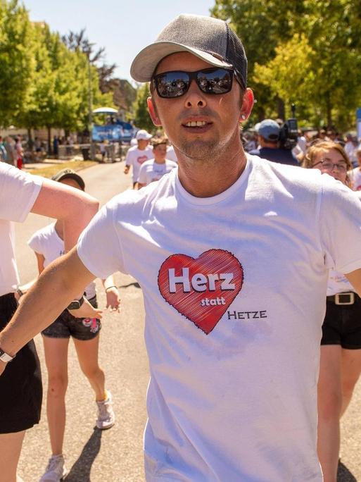 Impressionen vom Großen Umzug zum 17. Thüringentag 2019 in Sömmerda: Ein junger Mann mit einem T-Shirt auf dem "Herz statt Hetze" steht läuft beschwingt durch die Straßen - hinter ihm weirere junge Menschen mit weißen Herz-T-Shirts.