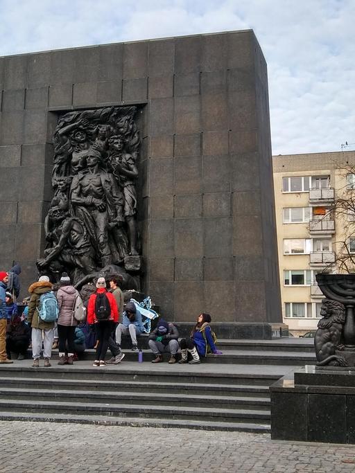 Gruppe Jugendlicher vor dem "Denkmal der Helden des Ghettos" in Warschau