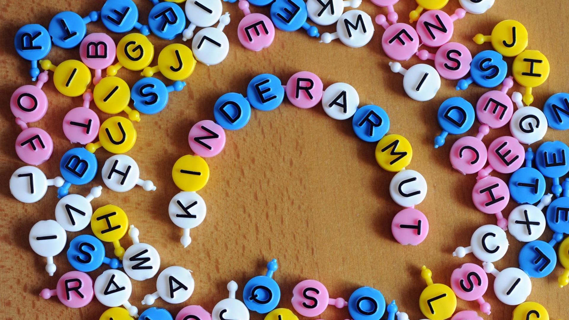 Aus einzelnen Buchstaben des Spiels "Buchstabensuppe" ist das Wort Kinderarmut gebildet