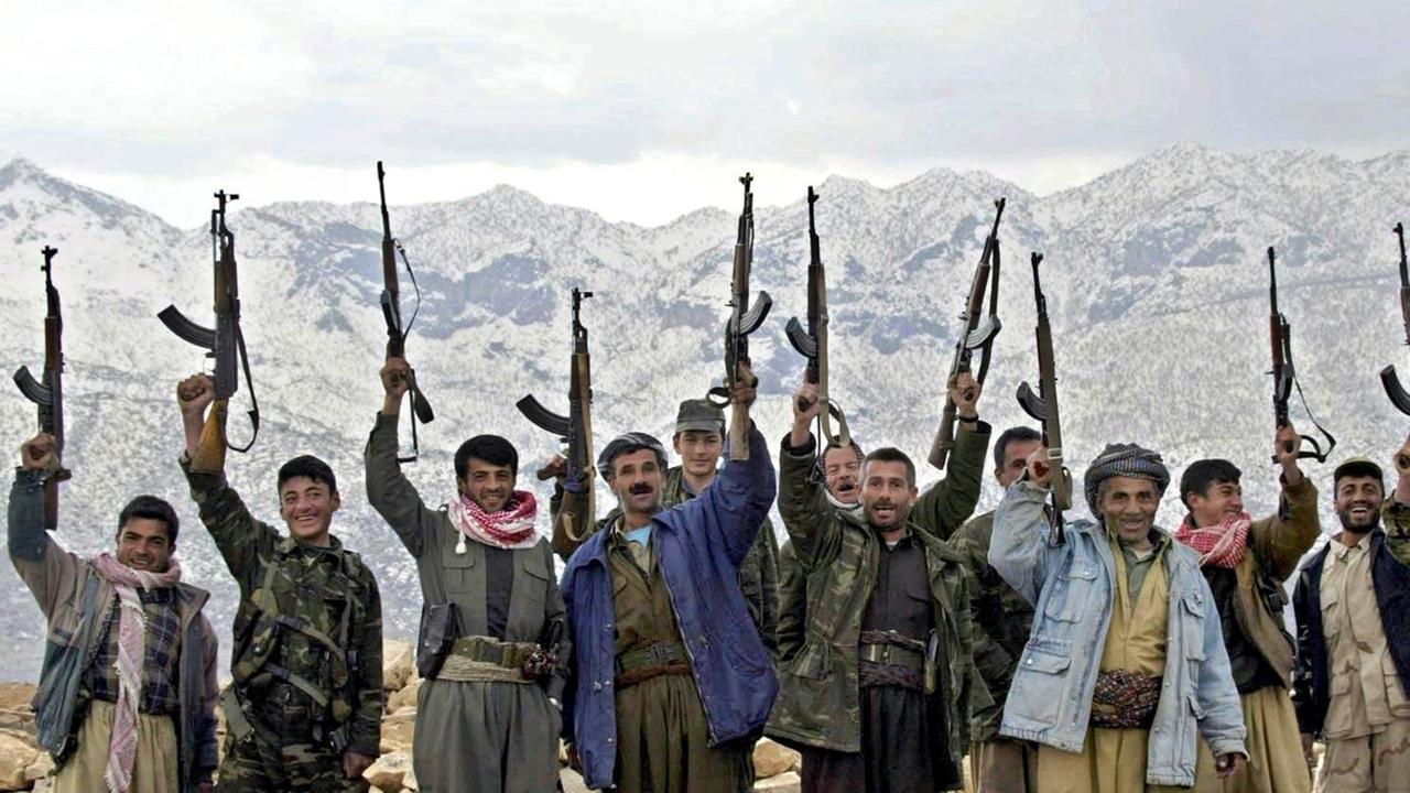 Kurdische Kämpfer und Anhänger der Demokratischen Partei Kurdistans (DPK) schwenken bei Kani Masi im Norden des Irak ihre Waffen.