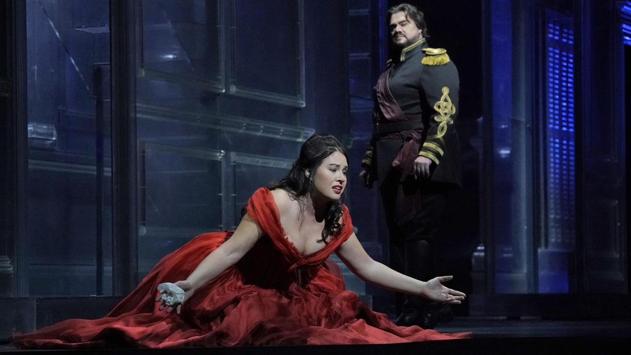 Desdemona im roten Kleid liegt Otello zu Füßen. Er schaut missbilligend zu ihr herunter. Desdemona im roten Kleid liegt Otello zu Füßen. Er schaut missbilligend zu ihr herunter.
