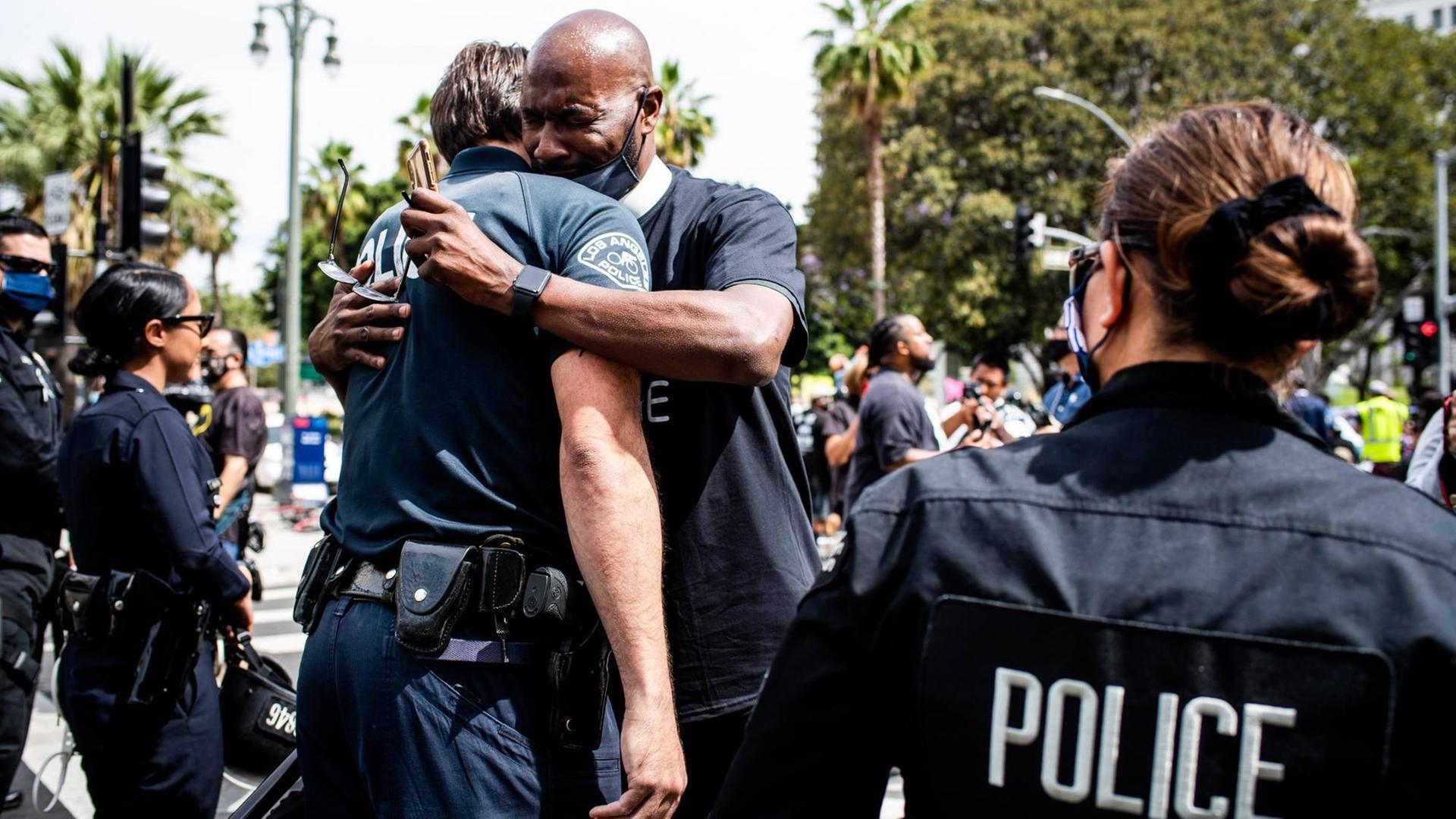 Ein Mann umarmt einen Polizisten