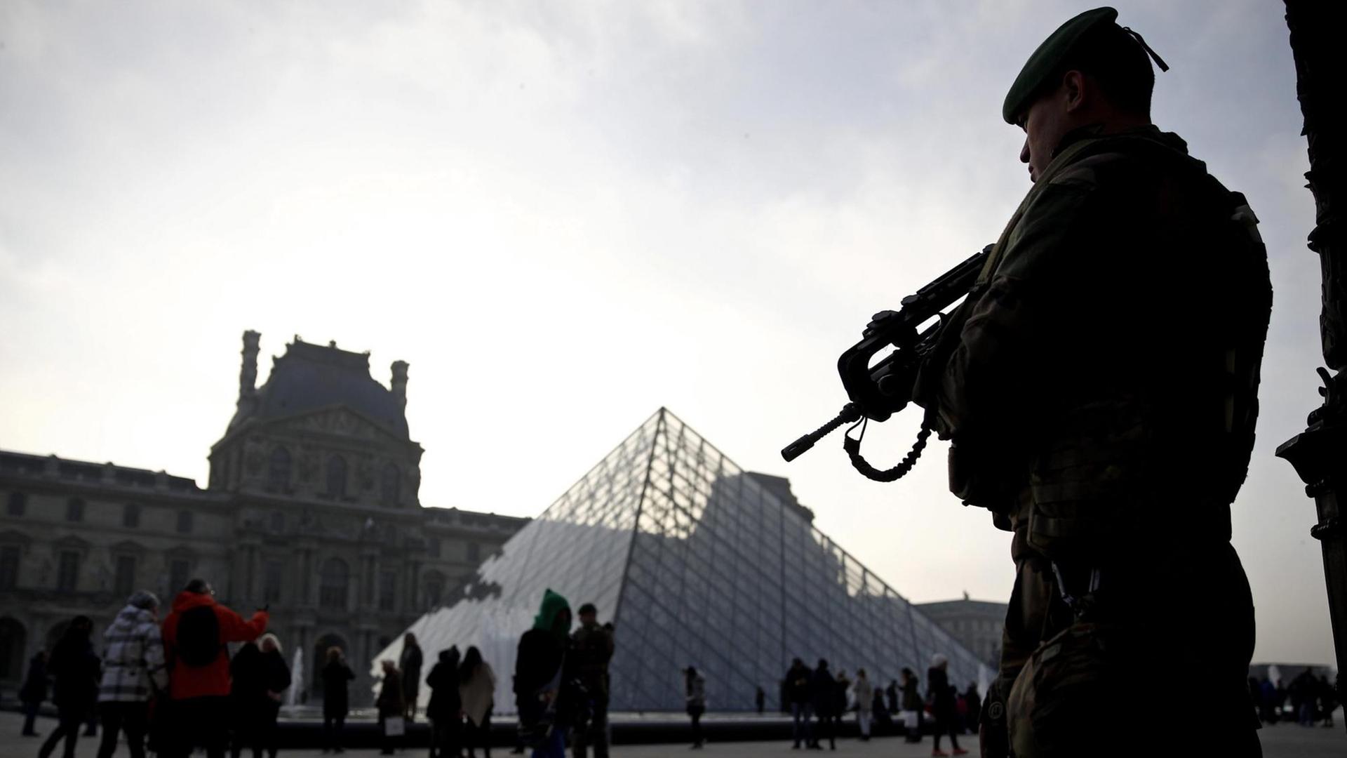 Ein Soldat auf dem Vorplatz vor dem Louvre.