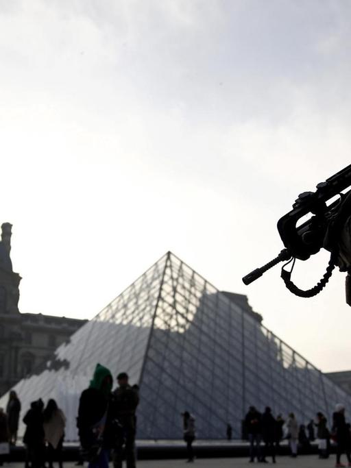 Ein Soldat auf dem Vorplatz vor dem Louvre.