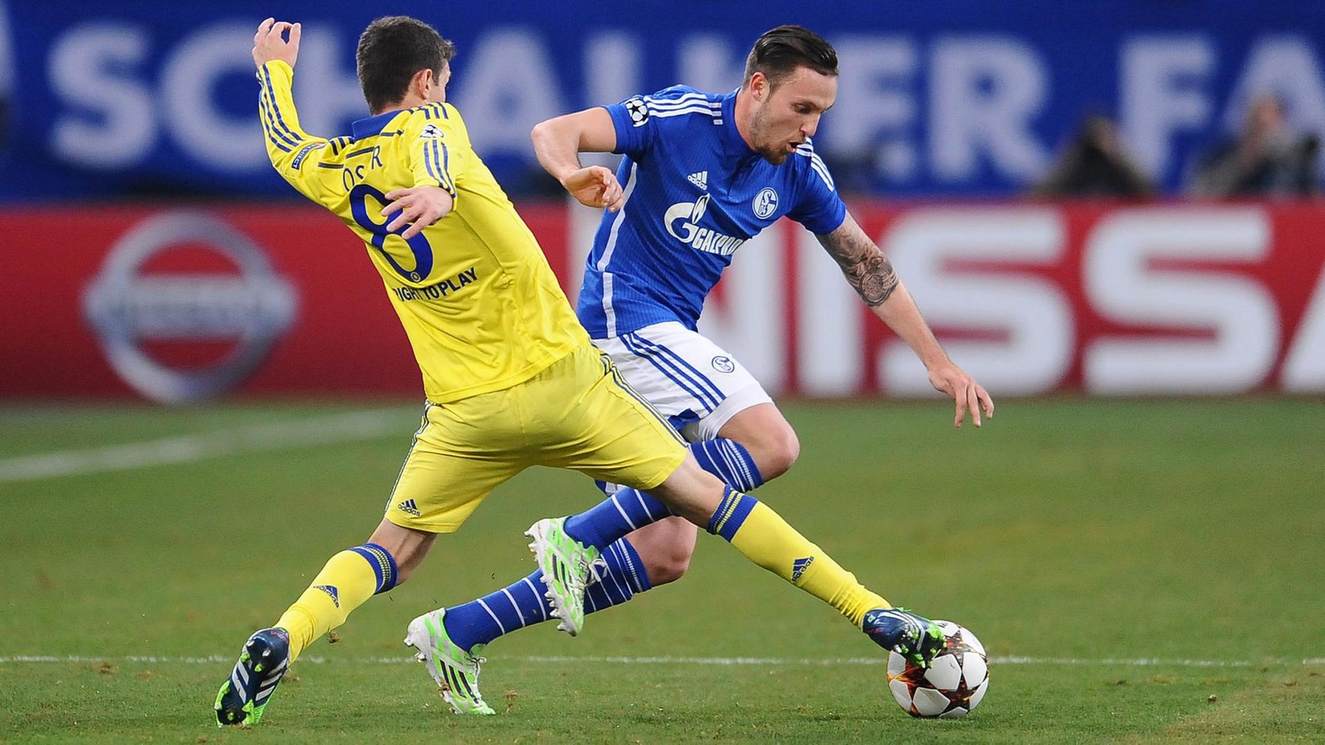 Der Chelsea-Spieler Oscar nimmt Marco Höger von Schalke den Ball ab.