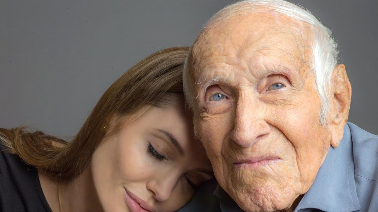 US-Schauspielerin und Regisseurin Angelina Jolie lehnt mit geschlossenen Augen an der Schulter des 96 Jahre alten US-Athleten und Kriegshelden Louie Zamperini (undatierte Aufnahme). Der frühere olympische Langstreckenläufer ist die Inspiration für Jolies zweite Regiearbeit. "Unbroken".