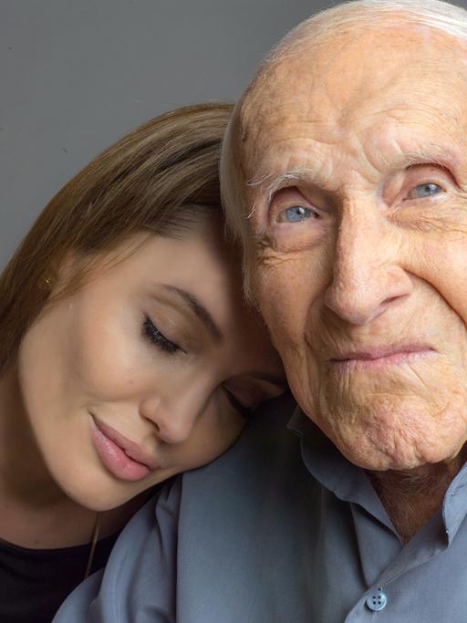 US-Schauspielerin und Regisseurin Angelina Jolie lehnt mit geschlossenen Augen an der Schulter des 96 Jahre alten US-Athleten und Kriegshelden Louie Zamperini (undatierte Aufnahme). Der frühere olympische Langstreckenläufer ist die Inspiration für Jolies zweite Regiearbeit. "Unbroken".