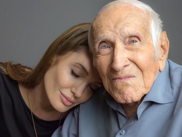 US-Schauspielerin und Regisseurin Angelina Jolie lehnt mit geschlossenen Augen an der Schulter des 96 Jahre alten US-Athleten und Kriegshelden Louie Zamperini (undatierte Aufnahme). Der frühere olympische Langstreckenläufer ist die Inspiration für Jolies zweite Regiearbeit. "Unbroken".