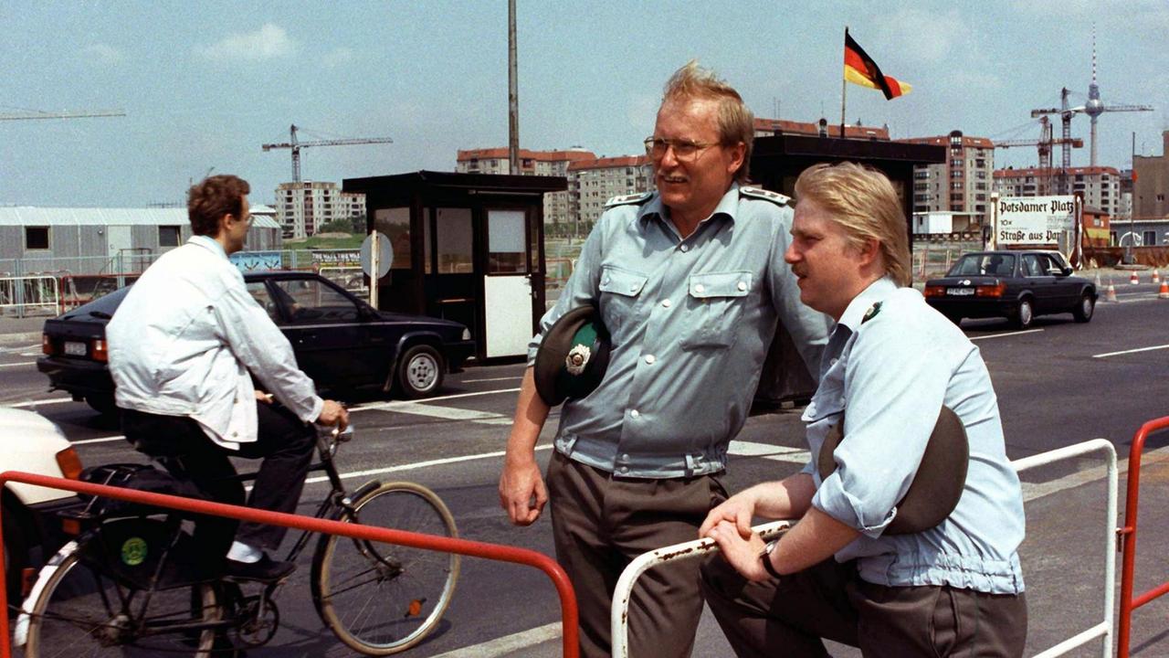DDR-Grenzsoldaten lassen am 29. Juni 1990 –zwei Tage vor Inkrafttreten des Staatsvertrages zwischen den beiden deutschen Staaten – Besucher am Potsdamer Platz in Ost-Berlin ungehindert passieren.