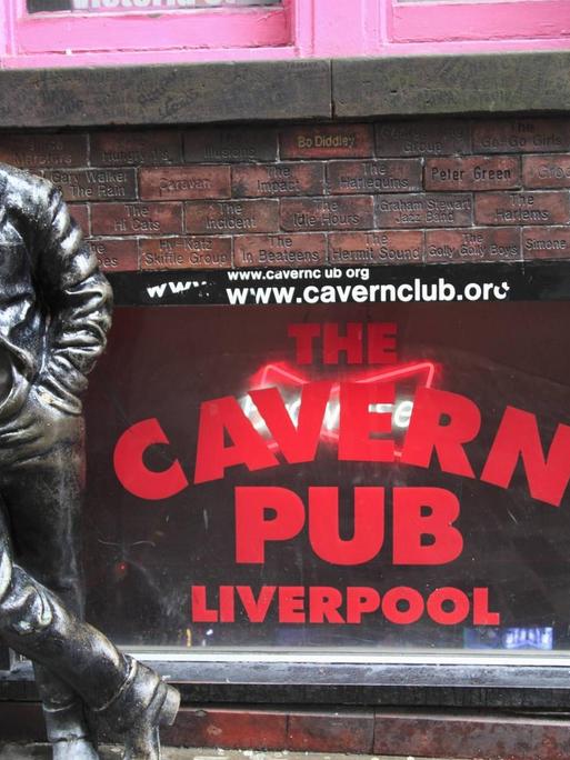 Die John Lennon-Skulptur in der, Mathew Street in Liverpool zeigt den Beatle, wie er sich an einen Eingang lehnt.