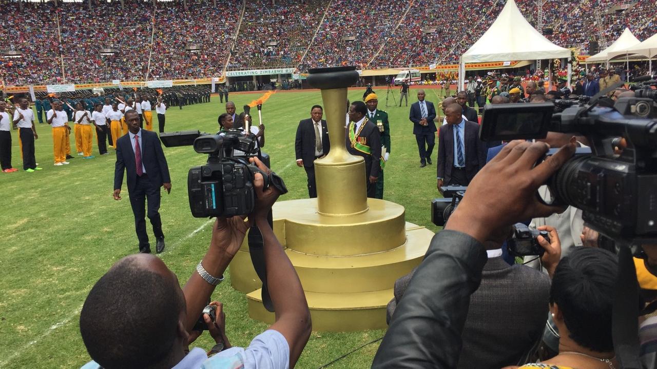 Präsident steht auf dem Rasen des Stadions vor Kameras