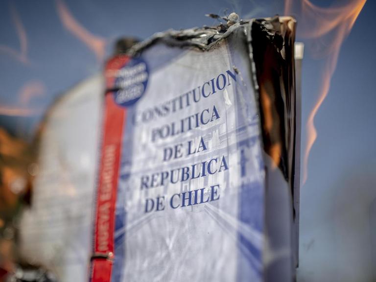 Deitailaufnahem eines brennenden Exemplars der chilenische Verfassung, während des Protestes zum 47. Jahrestag des letzten Militärputsches.
