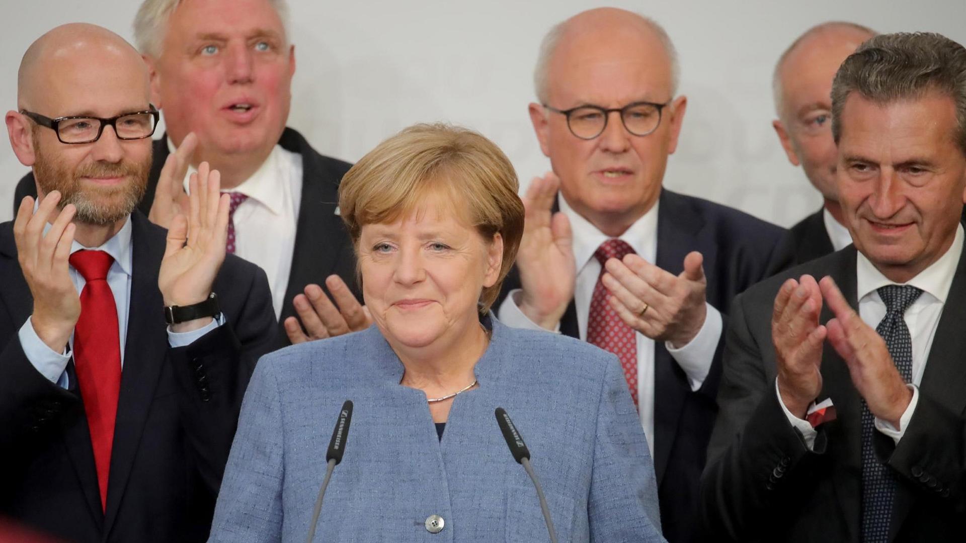 Bundeskanzlerin Angela Merkel (CDU) auf der Bühne in der CDU-Parteizentrale in Berlin, Deutschland, 24. September 2017. Bei der Wahlparty reagierte Merkel auf die ersten Hochrechnungen zur Bundestagswahl. (L-R) CDU-Generalsekretär Peter Tauber, Karl-Josef Laumann, CDU/CSU-Fraktionschef Volker Kauder und EU-Kommissar Günther Oettinger. Bild: Michael Kappeler/dpa