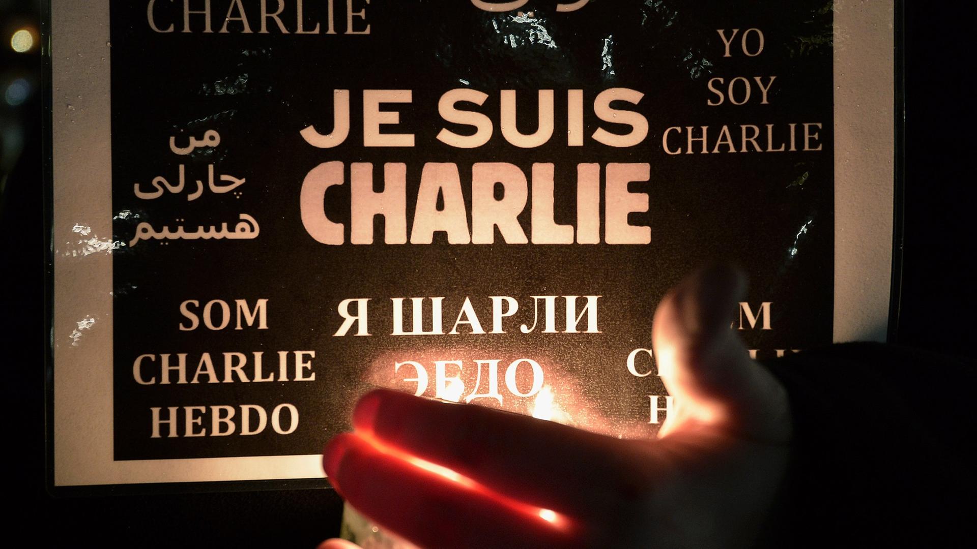 Eine Frau hält ein Poster mit einer Solidaritätsbekundung für "Charlie Hebdo" hoch