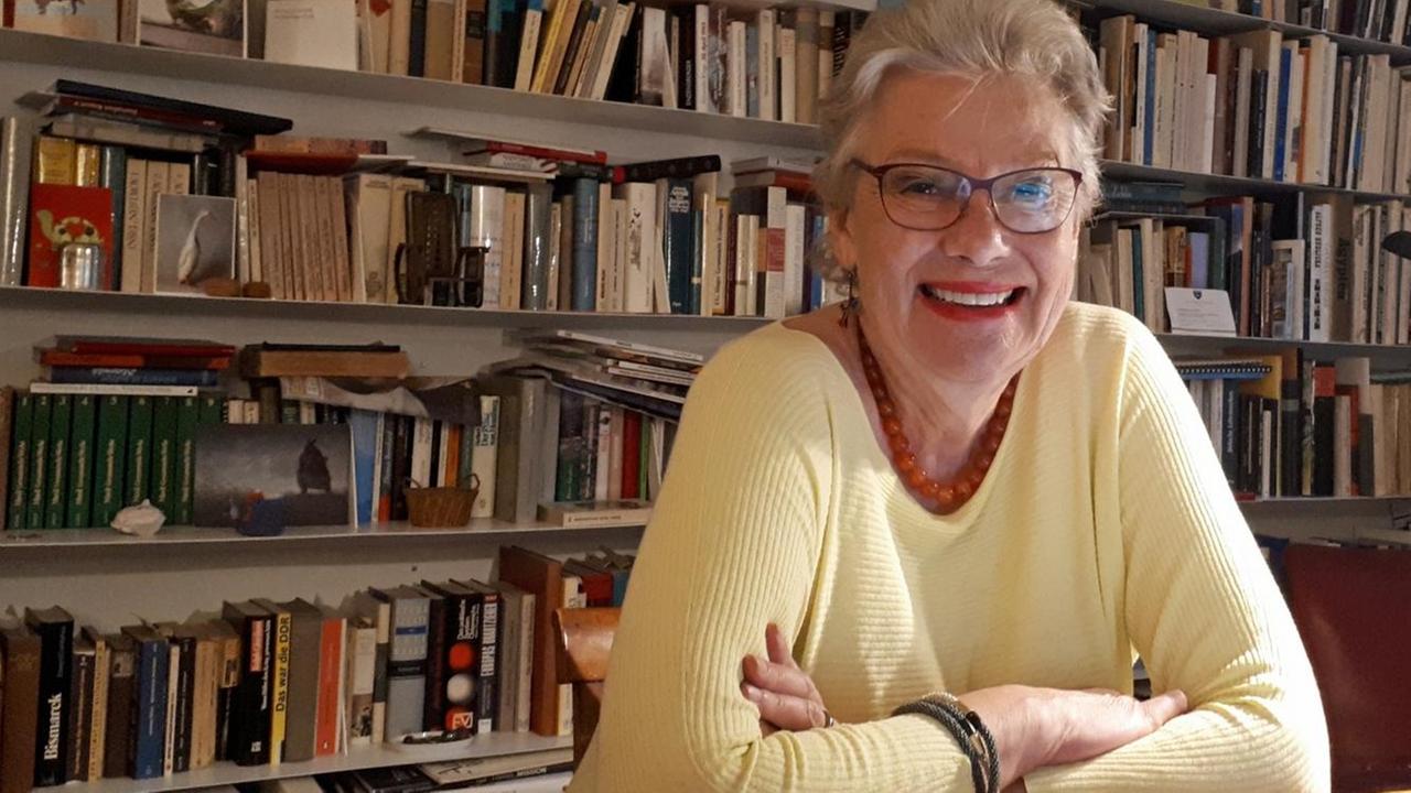 Porträt von Rubina Möhring, Präsidentin von Reporter ohne Grenzen Österreich, vor einer Bücherwand