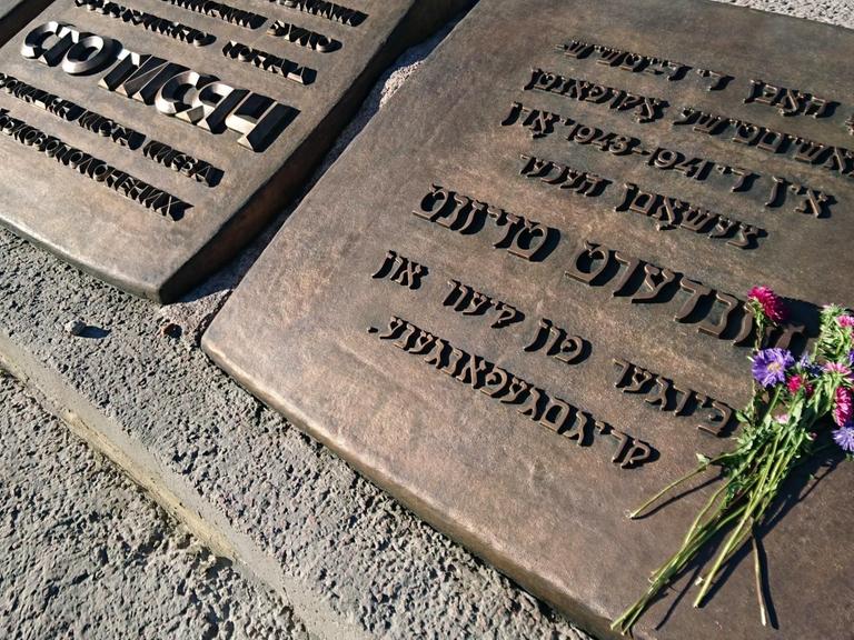 Blumen liegen auf Grabsteinen an der Gedenkstätte von Babi Jar, in der Nähe von Kiew