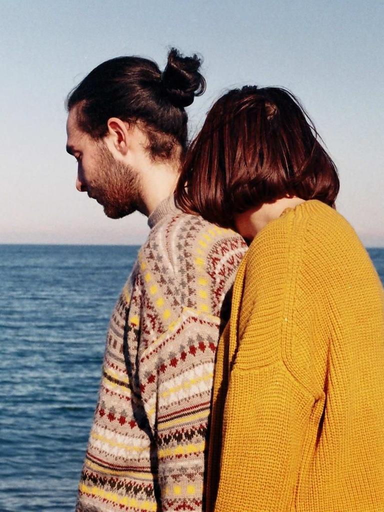 Mann und Frau in bunten Pullovern am Meer Mann und Frau in bunten Pullovern am Meer