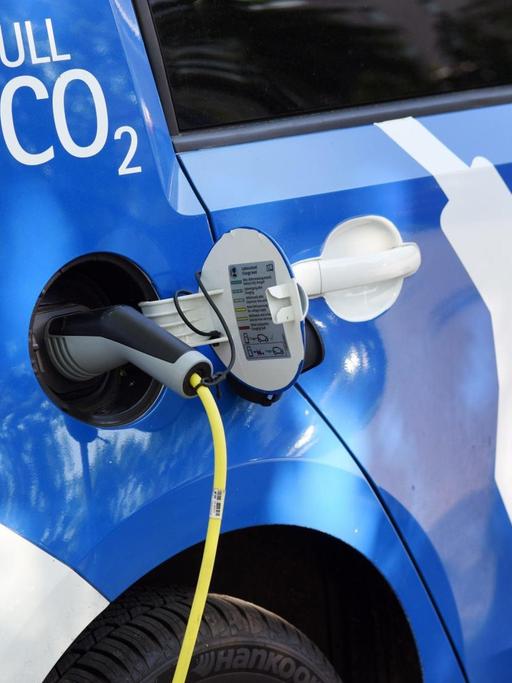 Ein Stromkabel ist am 10.05.2016 in Berlin (Berlin) an der Steckdose eines Elektroautos angeschlossen und am Auto ist der Schriftzug "NULL CO2" zu sehen.
