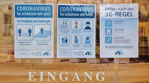 Ein Schild weißt im Eingangsbereich auf die Coronaregeln hin