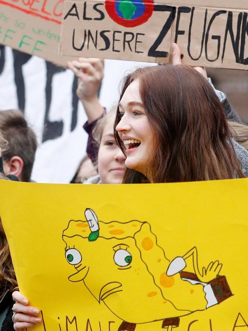 Schüler protestieren während einer Schülerdemonstration vor dem Düsseldorfer Rathaus mit einem Plakat "Unser Klima hat mehr Defizite als unsere Zeugnisse". Der Protest steht unter dem Motto "Fridays for Future".