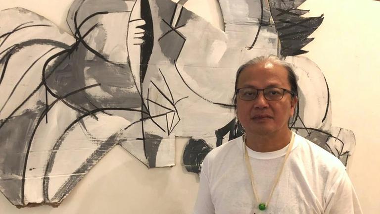 Hongkonger Maler und Galerist San Mu vor seinem Bild "Guernica"