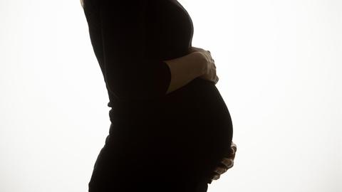 Eine schwangere Frau im Profil