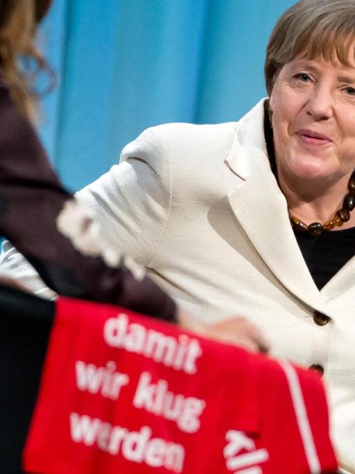 Angela Merkel auf einem Podium im Gespräch.
