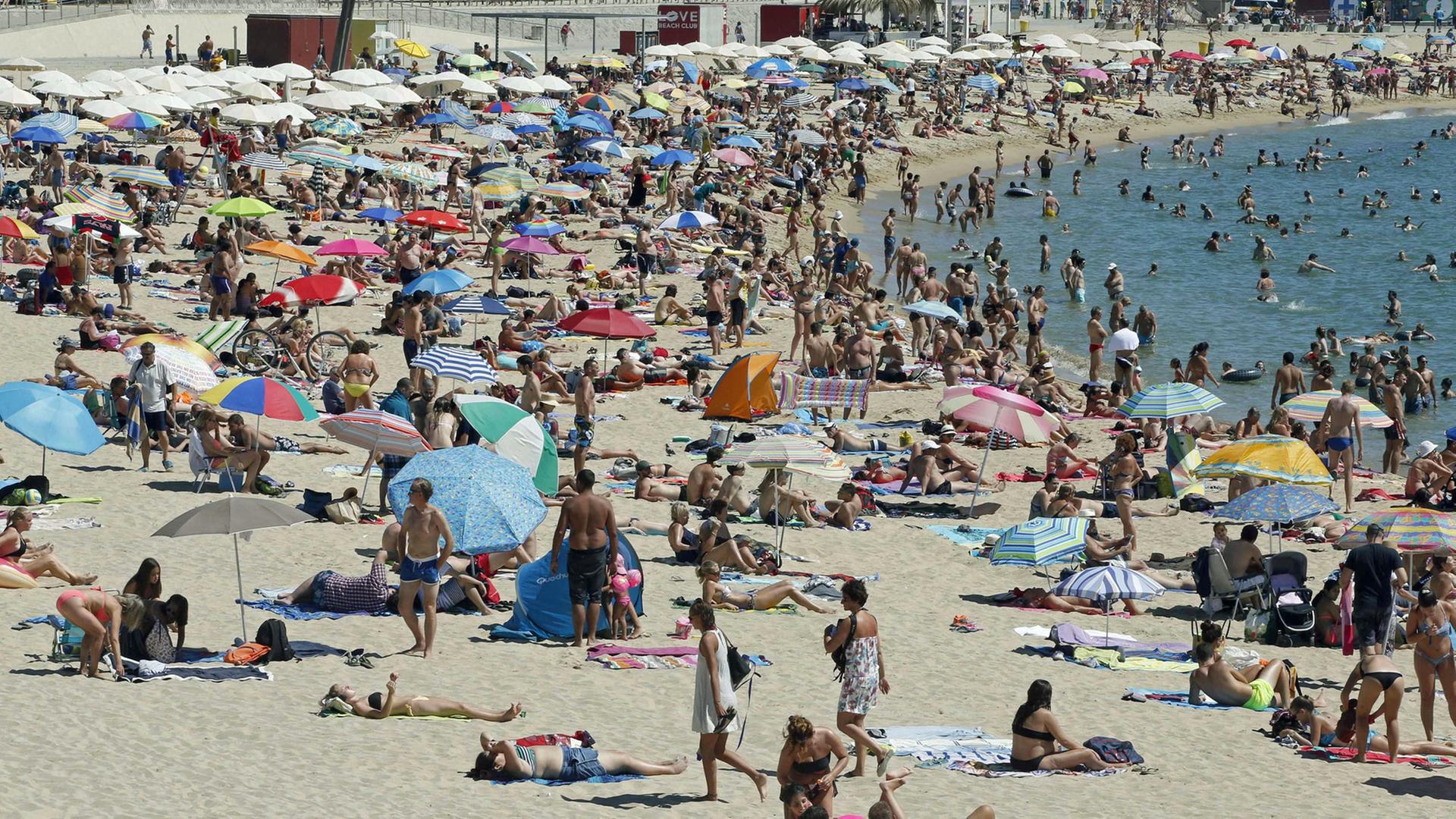 Tausende Touristen genießen die Sonne am Strand von Barcelona. Tausende Touristen genießen die Sonne am Strand von Barcelona.