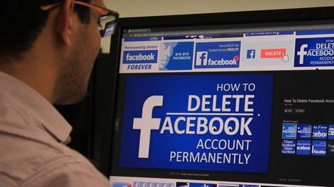 Ein Mann blickt auf einen Bildschirm, auf dem in verschiedenen Formen "Delete Facebook" angezeigt wird.