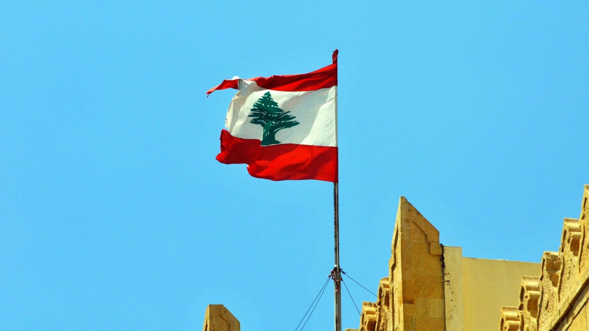 Eine libanesische Flagge an einem Gebäude in Beirut weht im Wind. Eine libanesische Flagge an einem Gebäude in Beirut weht im Wind.