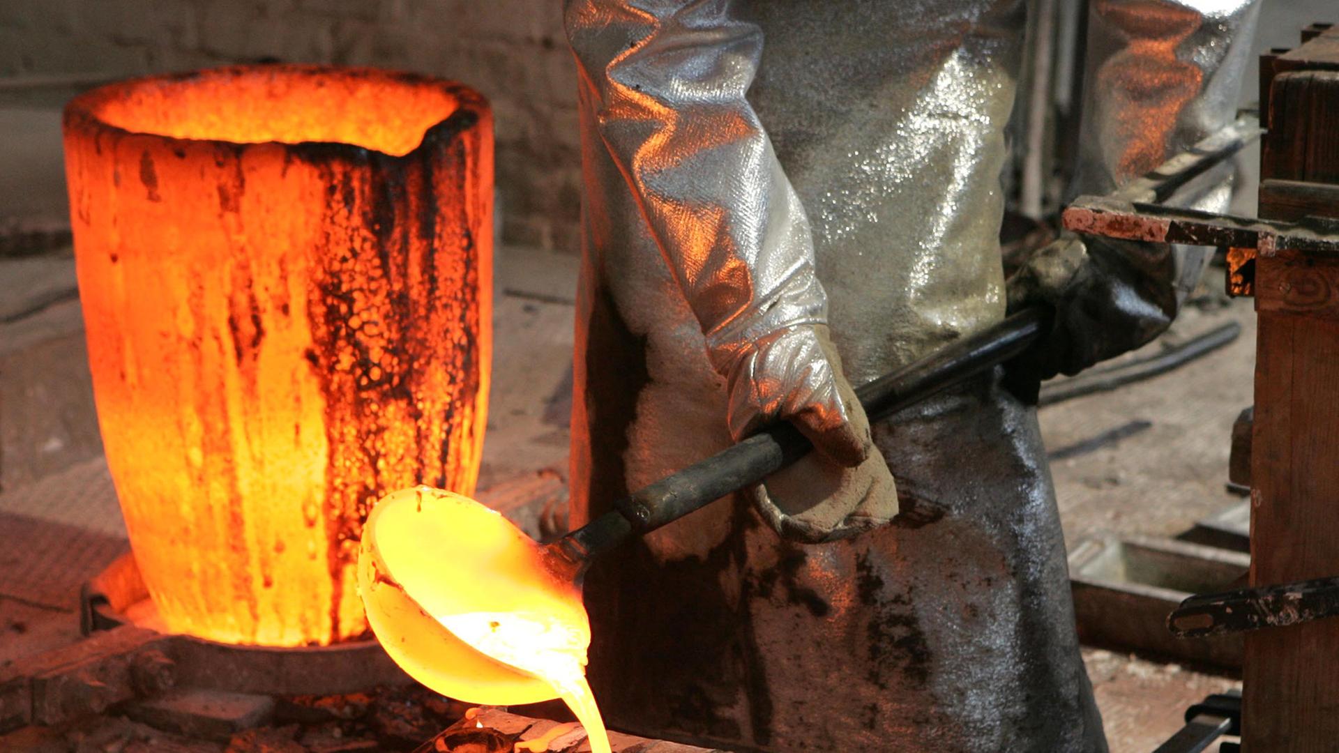 Flüssige Bronze wird in der Werkstatt der Bildgießerei Noack in Berlin in Formen gegossen.
