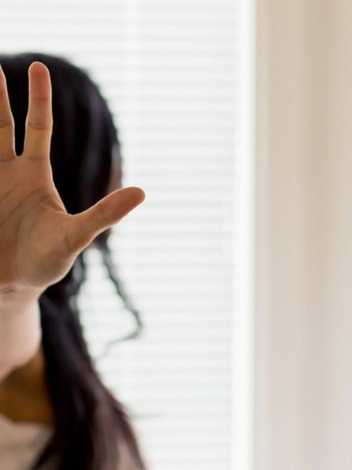 Eine Frau wird belästigt und hält die Hand zur Abwehr