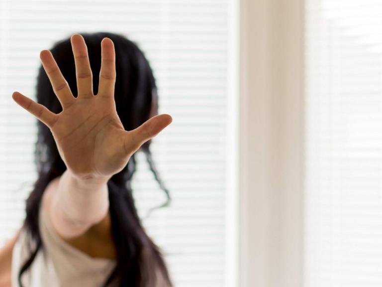 Eine Frau wird belästigt und hält die Hand zur Abwehr