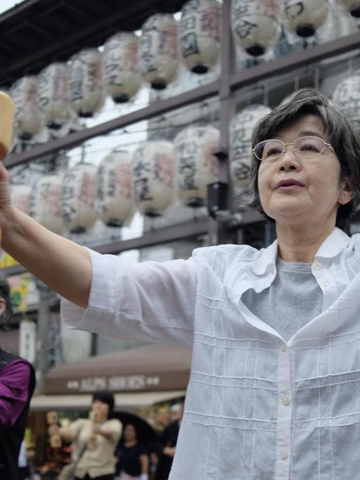 Elderly people work out with wooden dumb-bells in the grounds of a temple in Tokyo on September 19, 2016, to celebrate Japan's Respect for the Aged Day. / AFP PHOTO / KAZUHIRO NOGI