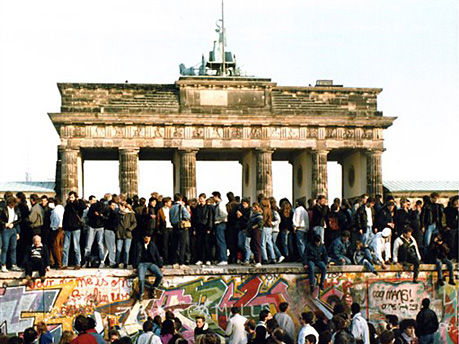 Am Tag nach der Öffnung am 9. November 1989 steigen Menschen auf die Berliner Mauer vor dem Brandenburger Tor in Berlin.