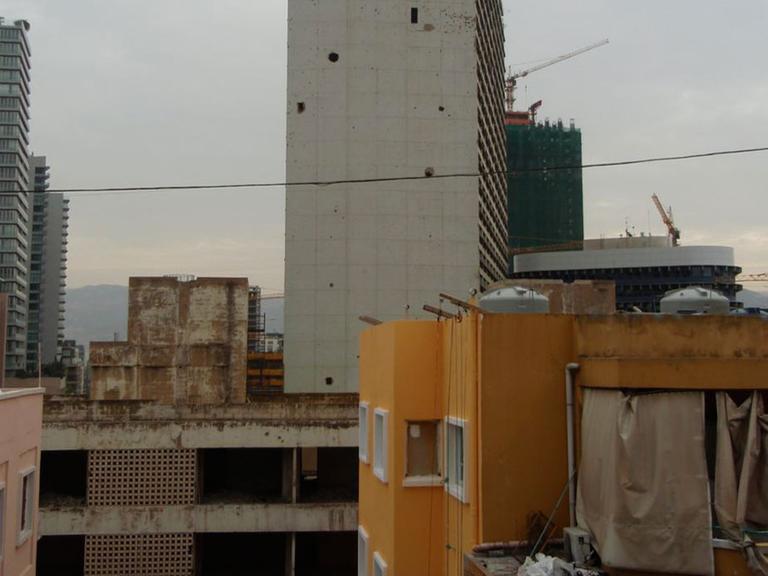 Wie Mahnmale stehen die leeren Hochhäuser mitten in Beirut. Seit den Kämpfen 2005 wurden die Häuser mit den Einschlusslöchern nicht weitergebaut, obwohl Beirut einen Bauboom erlebt.