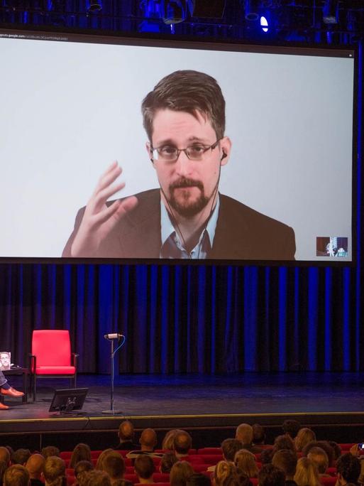 Edward Snowden ist im September 2019 auf einer Video-Leinwand in der Urania in Berlin zu sehen, während er bei einer Liveübertragung über sein Buch "Permanent Record: Meine Geschichte" spricht.
