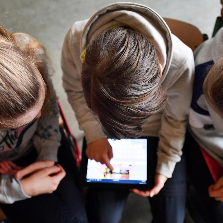 Schüler arbeiten mit einem Tablet.