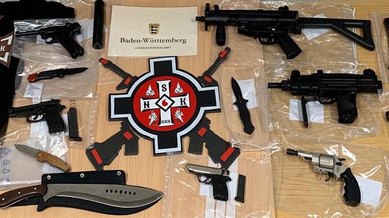 Das Foto der Staatsanwaltschaft Stuttgart zeigt Waffen und Embleme rechter Gruppiereungen nach einer Razzia gegen mutmaßliche Ku-Klux-Klan-Mitglieder auf einem Tisch.