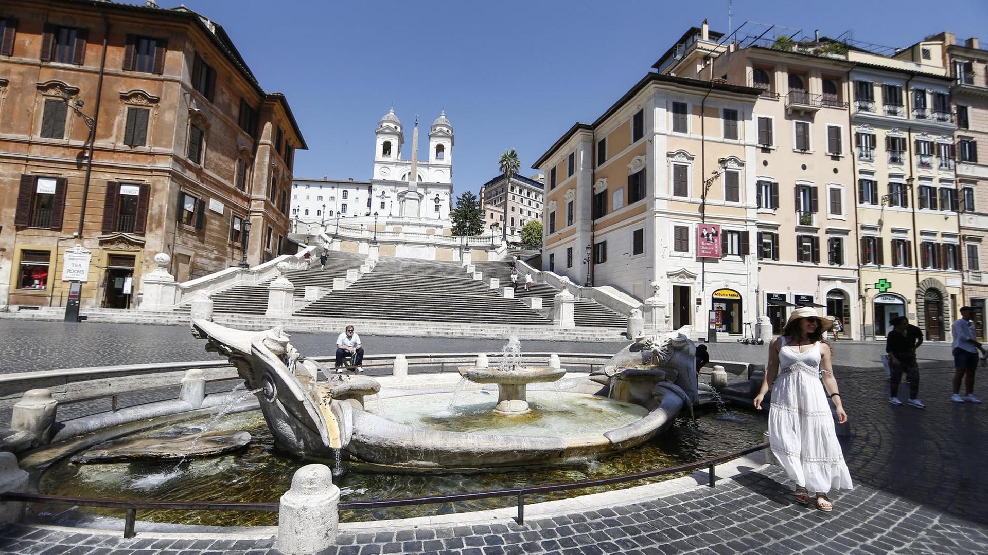 Einzelne Touristen stehen am Brunnen «Fontana della Barcaccia» vor der Spanischen Treppe in Rom, einem der Touristen-Hotspots.
