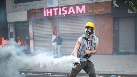 Demonstrant bei Protesten nahe des Taksim-Platzes werfen CS-Patronen zurück.