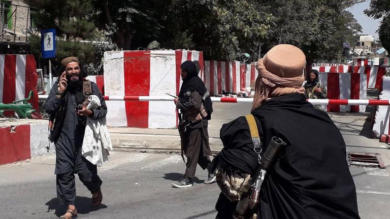 Mitglieder der Taliban vor einr Straßenabsperrung