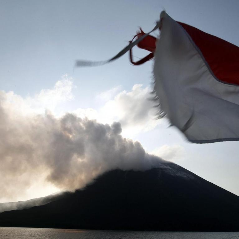Blick auf den Anak Krakatau vom Meer aus am 26. August 2013. im Vordergrund weht eine indonesische Flagge.