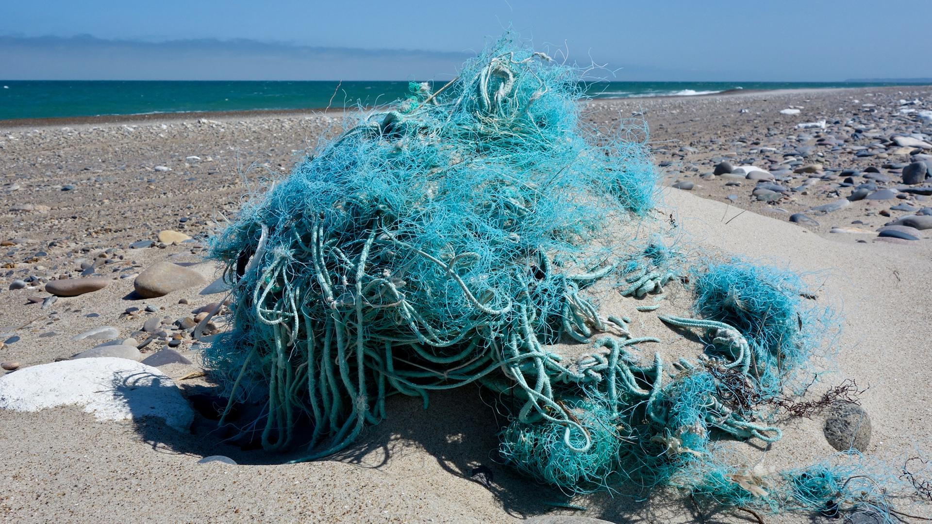 Am Nordseestrand an der Westküste von Dänemark nahe dem Ort Agger liegt ein Haufen vom Meer angespülter Fischernetze und Seile.