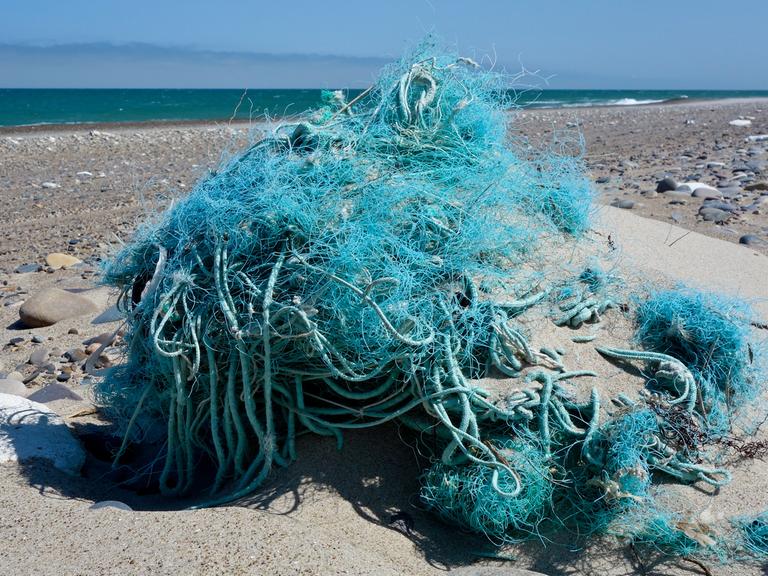 Am Nordseestrand an der Westküste von Dänemark nahe dem Ort Agger liegt ein Haufen vom Meer angespülter Fischernetze und Seile.